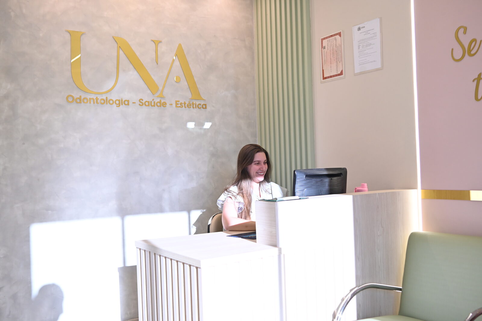 Recepção da Una Odontologia em Goiânia — ambiente acolhedor com logo dourado